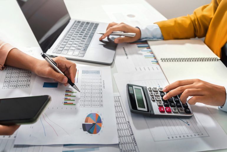 Kalkulationen, mit Diagrammen, Laptop und Taschenrechner